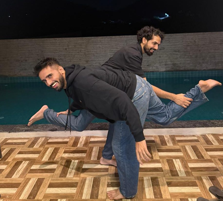 The two founders of Gracias Granny fooling around by a pool at night